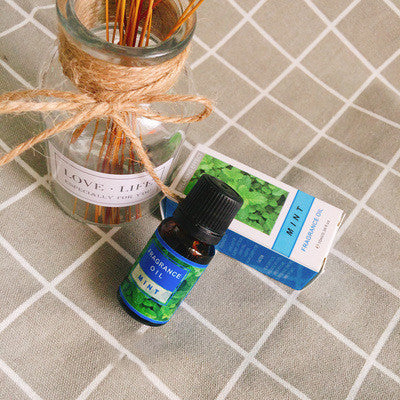 Bottle of FLIPSTYLEZLLC plant aromatherapy essential oil with fresh herbs and botanical elements in a glass container.
