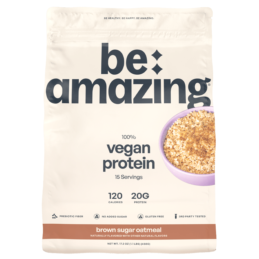 Be Amazing vegan protein powder in brown sugar oatmeal flavor, showing the container with label and scoop on a wooden surface.