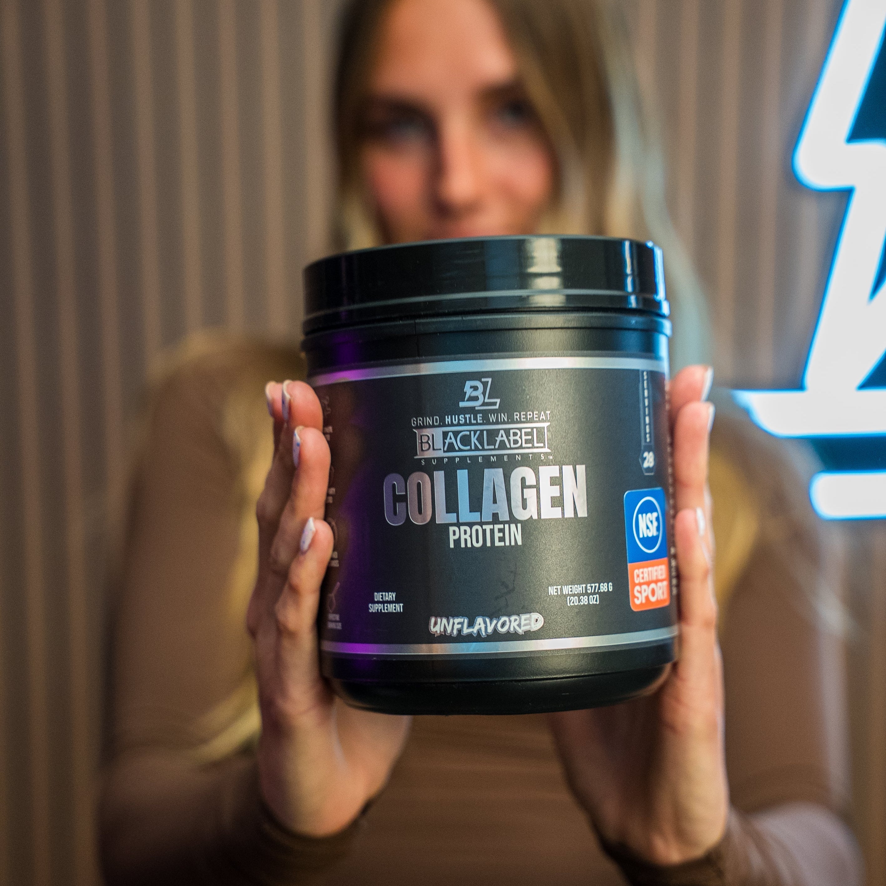 BlackLabel Supplements Collagen Protein powder in a resealable container, showing the product label and scoop inside.
