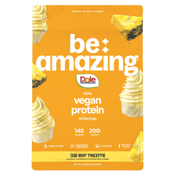 Be Amazing vegan protein powder with Dole Whip pineapple flavor, shown in a scoop on a white background.