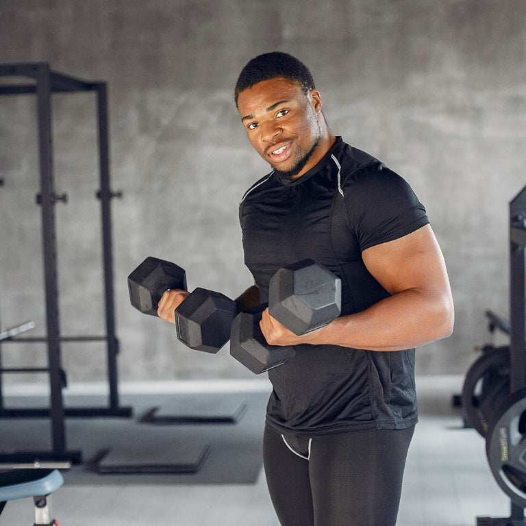 Man exercising with dumbbells in a gym setting