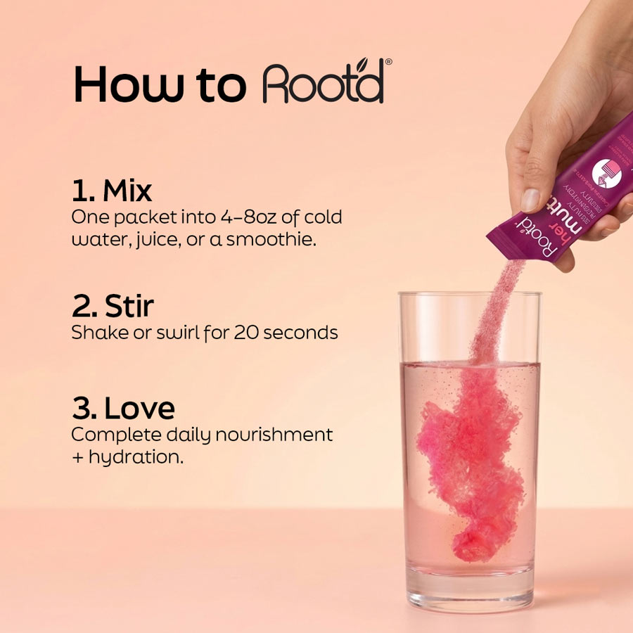 Root'd Advanced Daily Nutrition for Her multivitamin bottle on a kitchen counter with a glass of water.