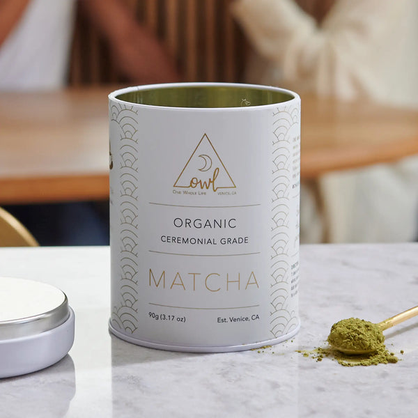 Organic Matcha Powder by OWL Venice in a green container, finely ground bright green matcha tea powder on a white background.