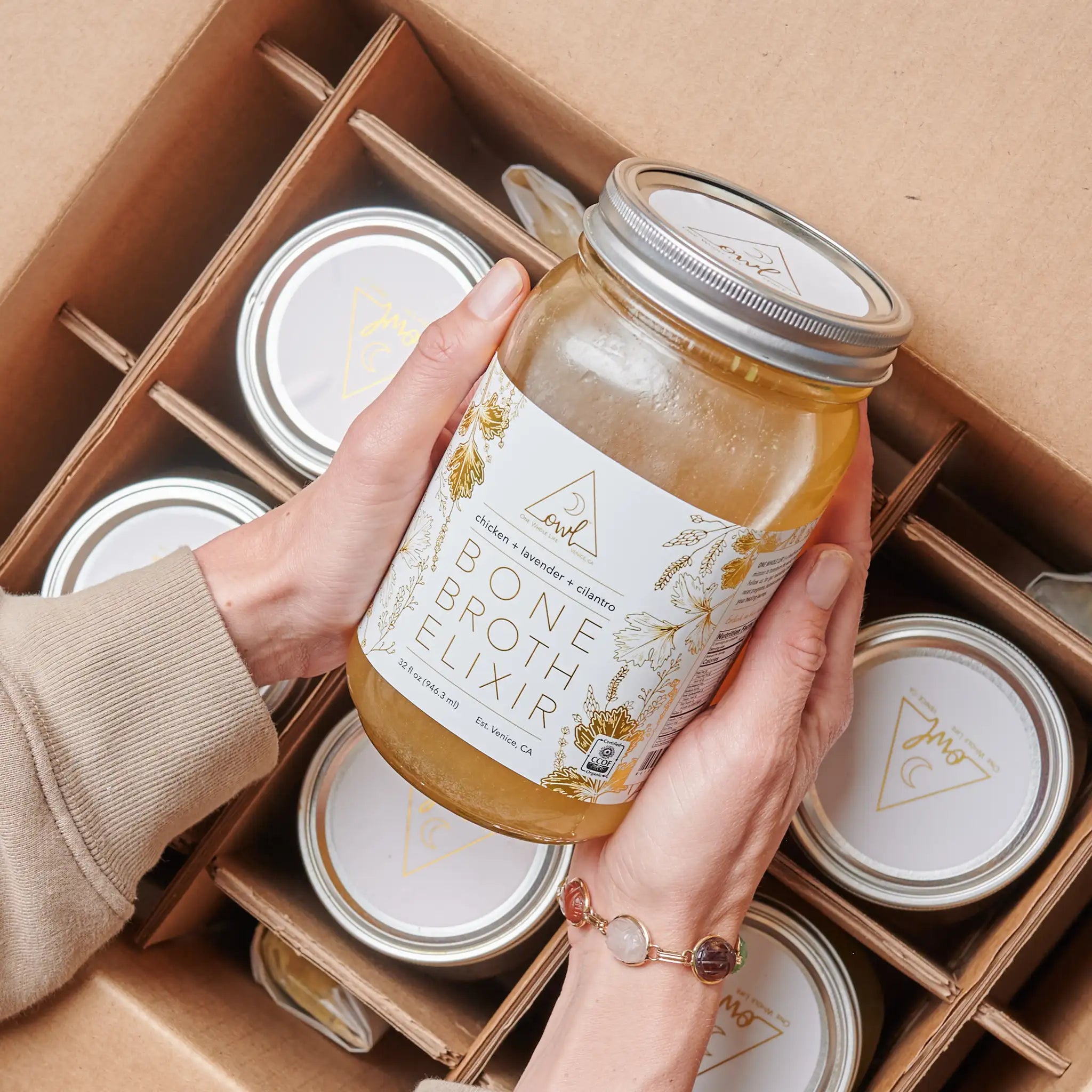 OWL Venice Organic Chicken Bone Broth Elixir in a glass bottle, showcasing the nourishing bone broth for health and wellness.