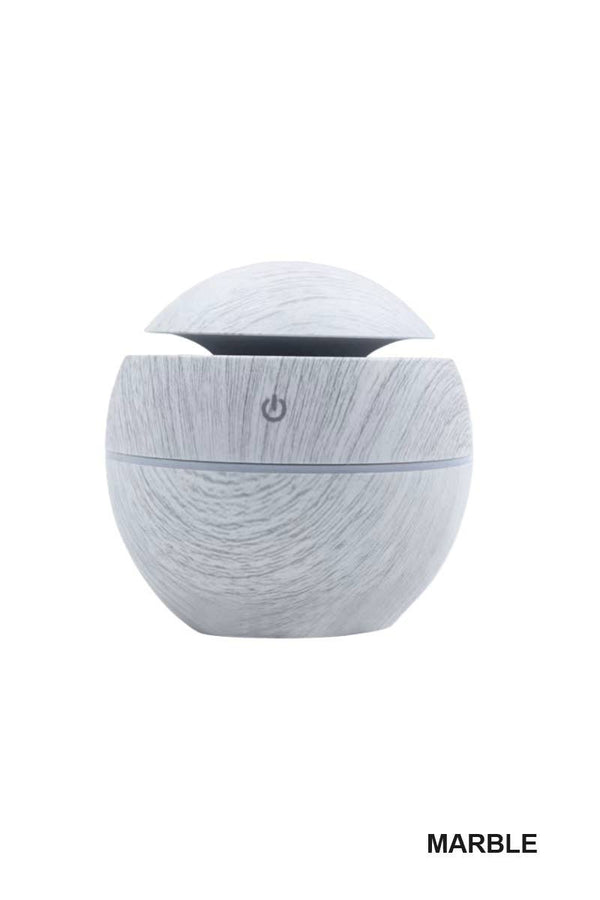 BioWizdom Tik Tok ultrasonic humidifier aroma therapy diffuser on marble surface, showing its compact design and mist outlet.