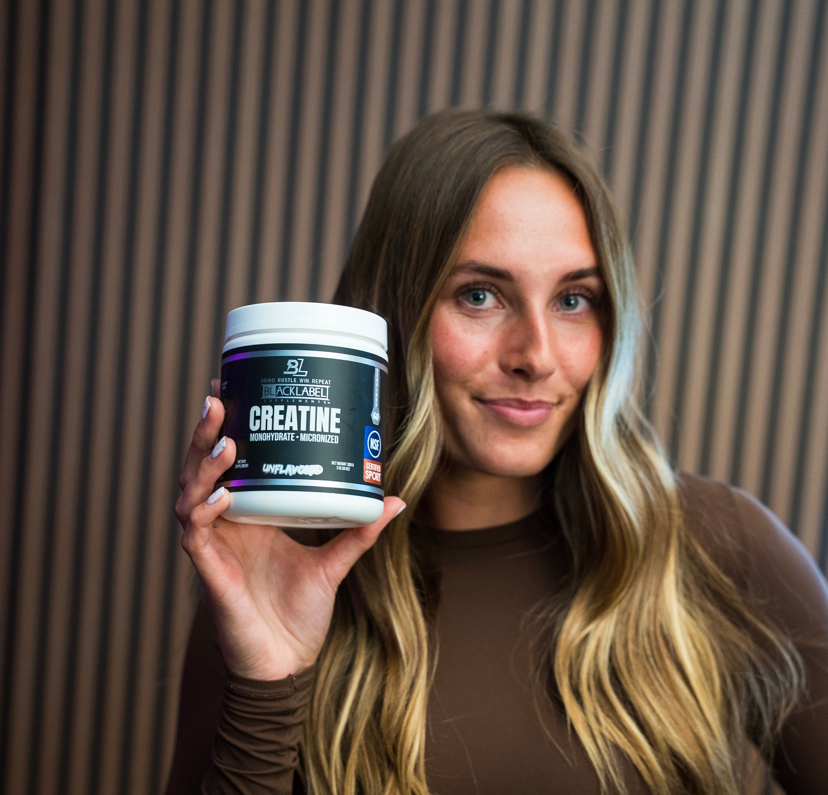 Container of BLACKLABEL Supplements creatine monohydrate powder with label visible in a clean, minimalist setting.