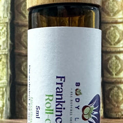 Body Love Self Care essential diffuser oils in travel-sized roll-ons, including Bandit's Brew scent, displayed in a close-up image.