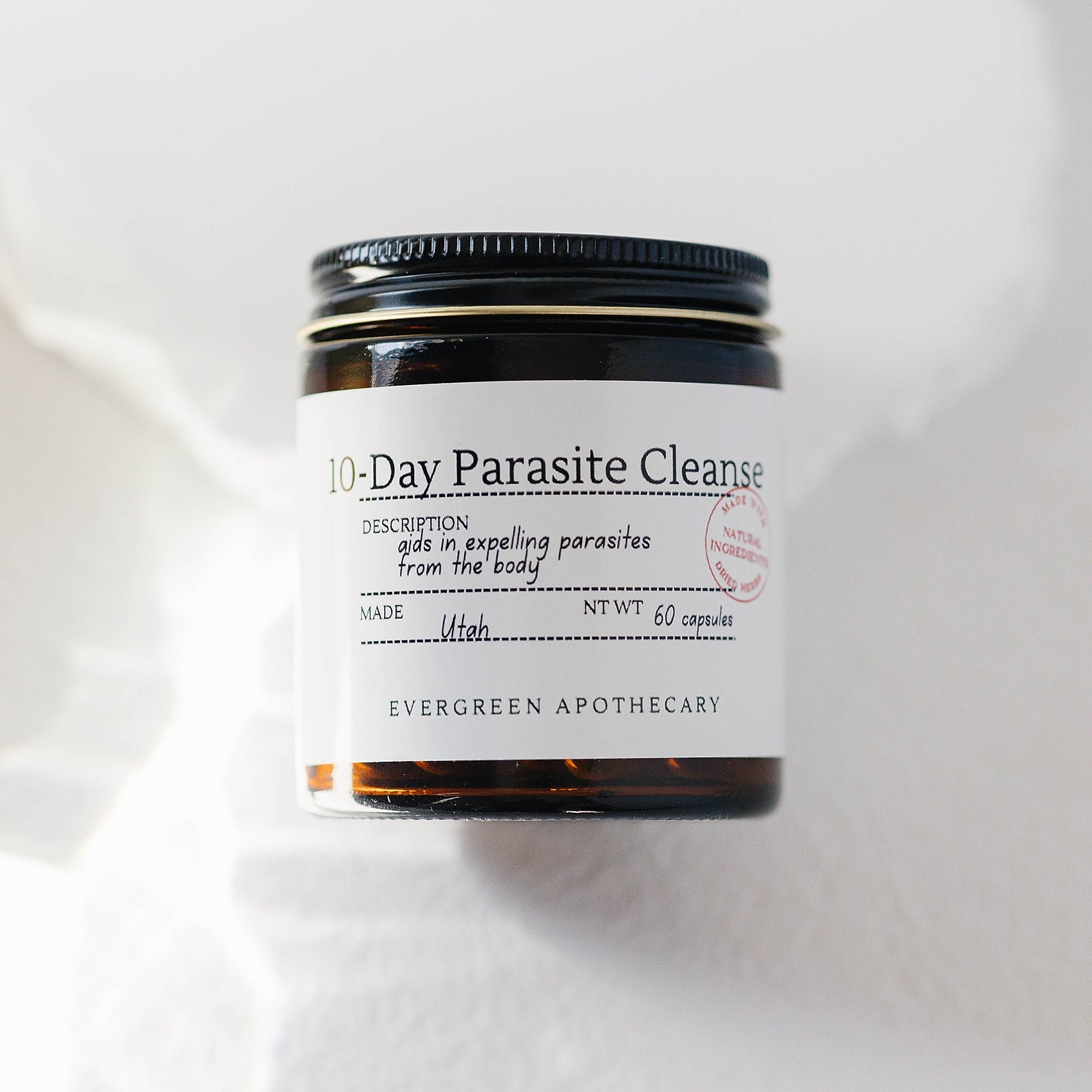 Herbal Wellness Capsules by Evergreen Apothecary featuring a botanical blend in a clear capsule for natural health support.