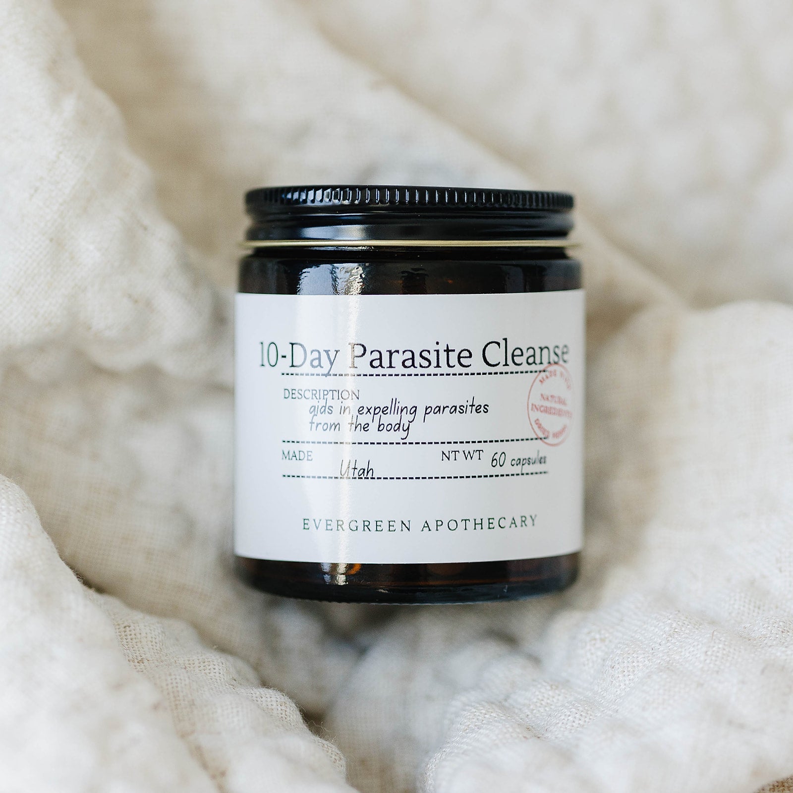 Herbal Wellness Capsules by Evergreen Apothecary showing a close-up of botanical blend capsules in a clear container.