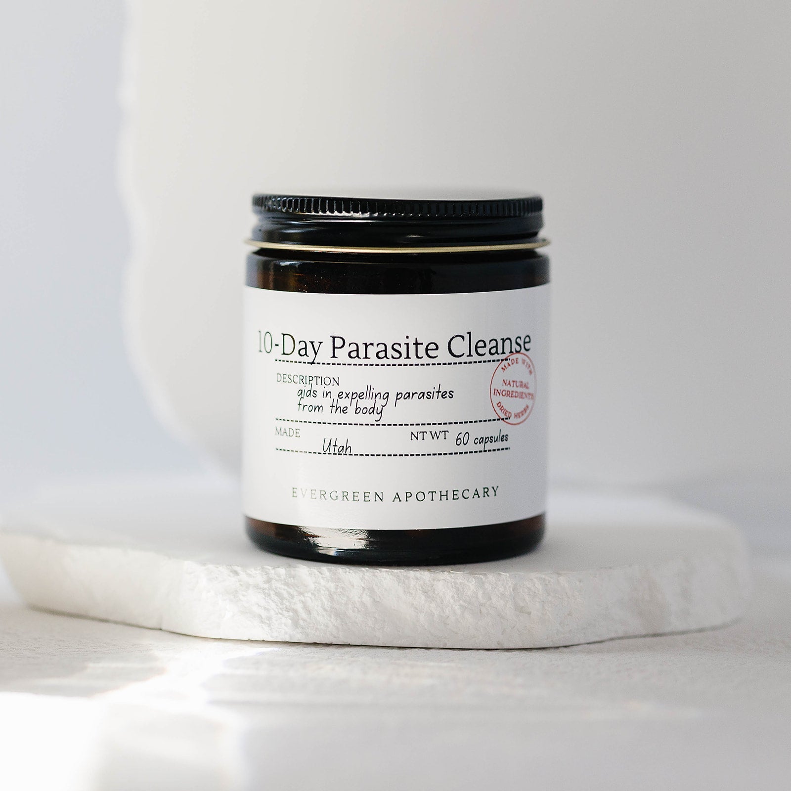 Herbal Wellness Capsules by Evergreen Apothecary, botanical blend supplement in a clear capsule showing herbal ingredients inside.