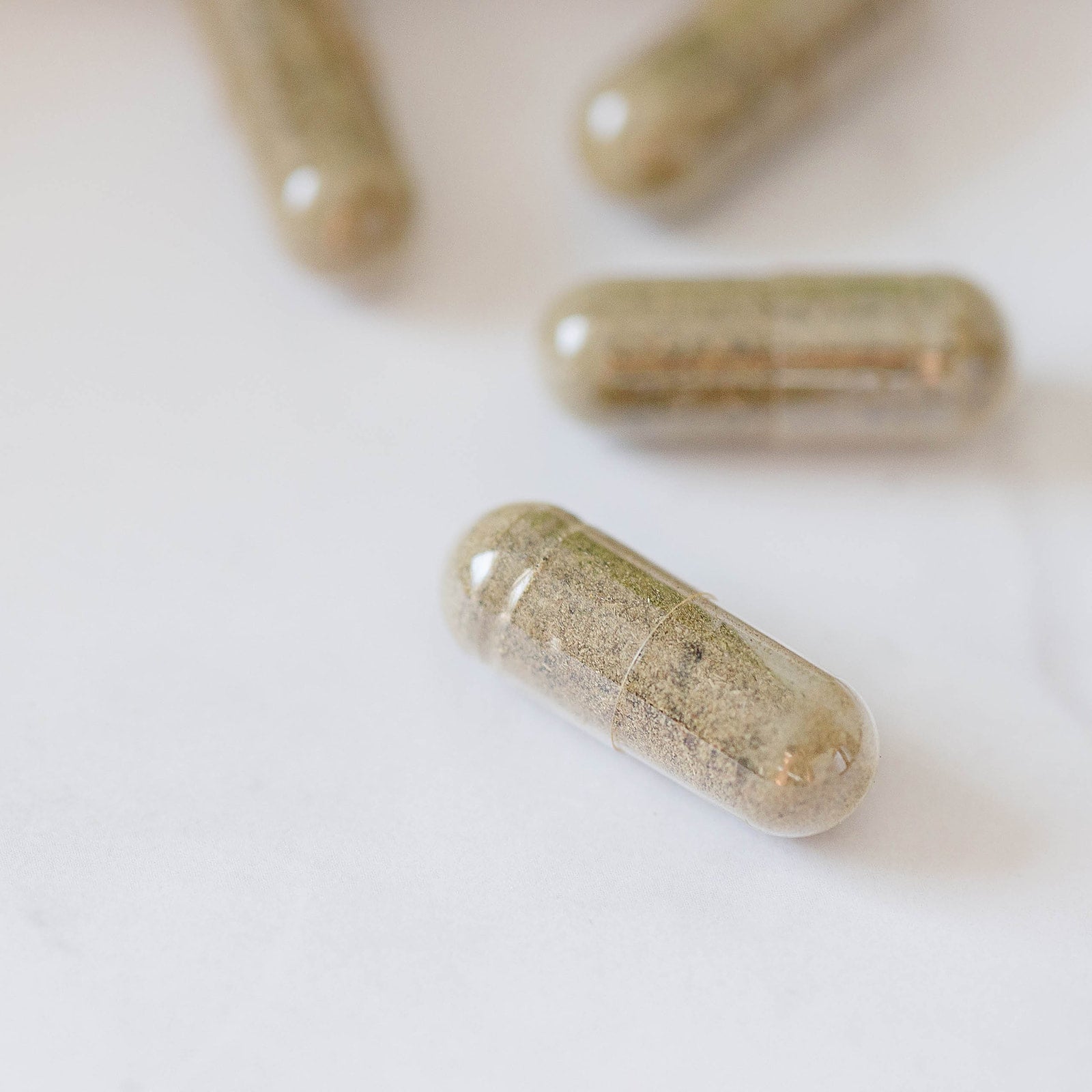 Herbal Wellness Capsules by Evergreen Apothecary showing a close-up of botanical blend supplement capsules in a bottle.