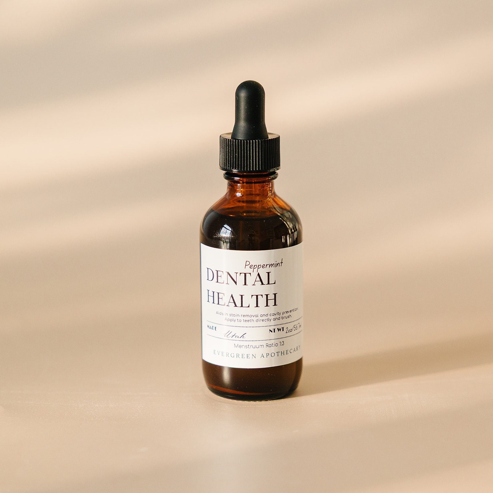 Evergreen Apothecary Dental Health Oil Brushing supplement with peppermint, showing a dropper and peppermint leaves.