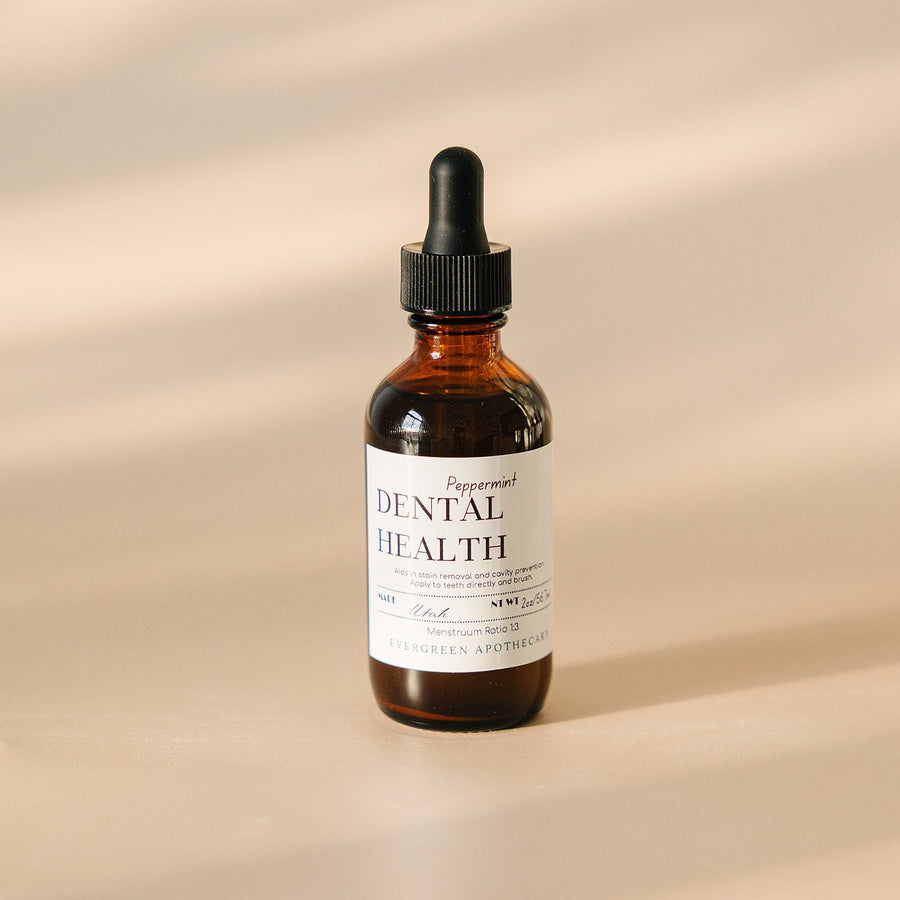 Evergreen Apothecary Dental Health Oil Brushing supplement with peppermint, showing a dropper and peppermint leaves.