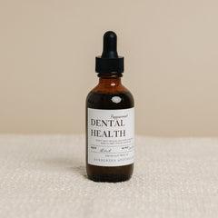 Evergreen Apothecary Dental Health oil brushing supplement with peppermint flavor, featuring a dropper bottle and fresh mint leaves.