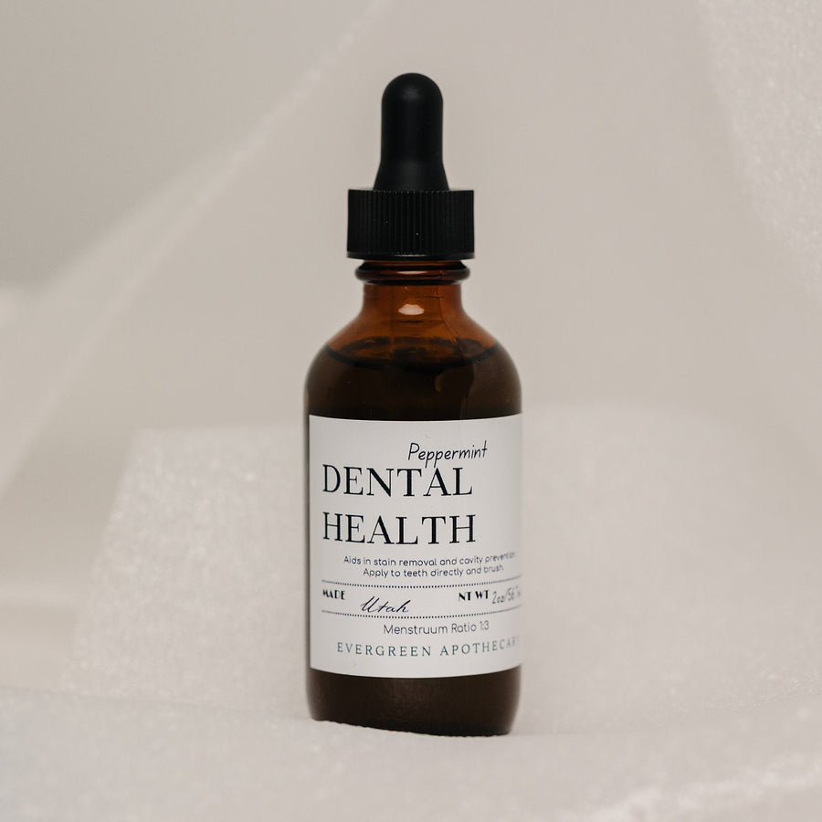 Evergreen Apothecary Dental Health Oil Brushing supplement with peppermint flavor, showing the bottle, label, and fresh mint leaves.