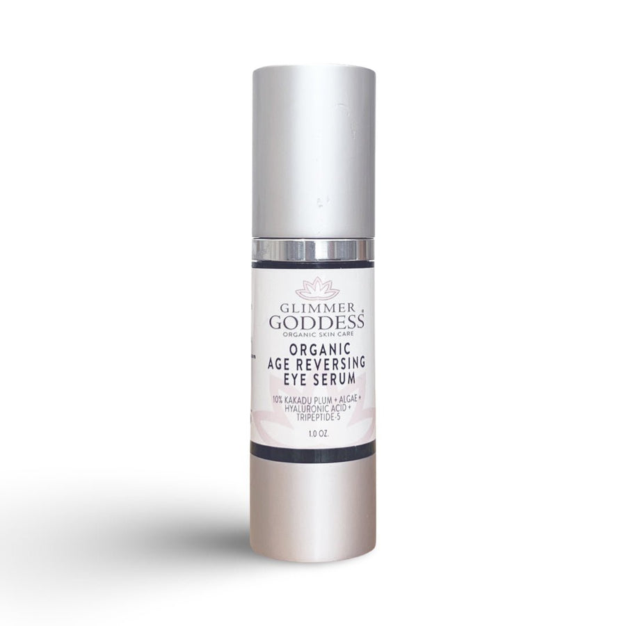 Organic age reversing eye serum by Glimmer Goddess for eyes, featuring a sleek bottle with a dropper and fresh botanical accents.