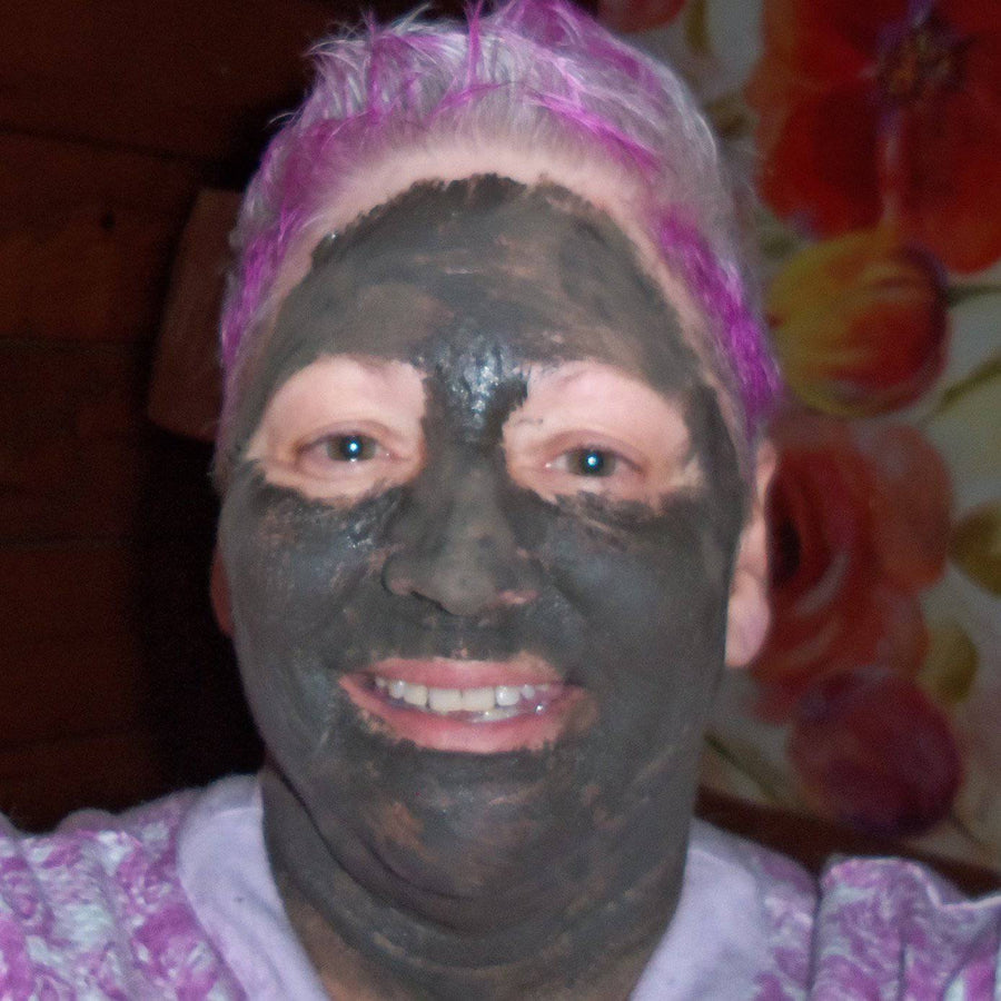 Glimmer Goddess Organic Dead Sea Mud Mask for exfoliating and rejuvenating skin in a 2 oz jar, with natural clay and mineral-rich formula.
