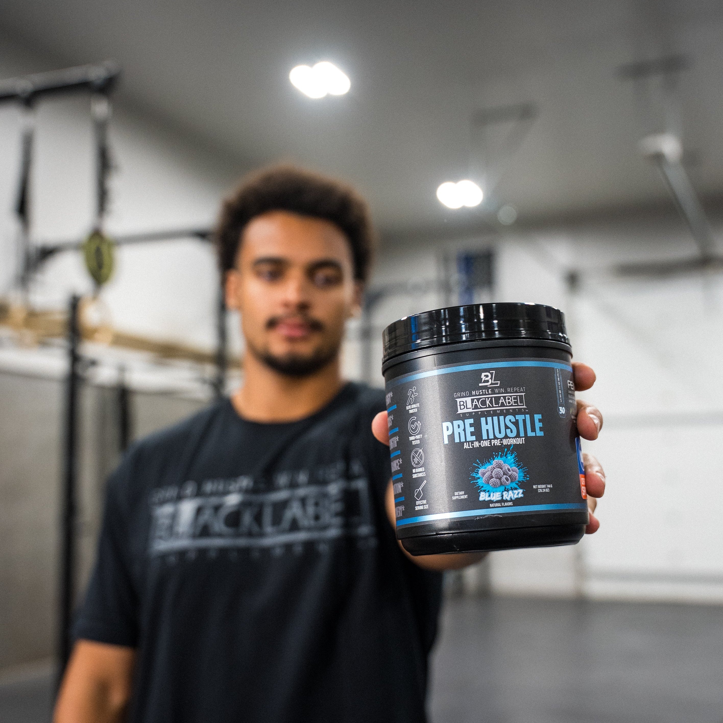 BlackLabel Supplements PRE HUSTLE V3 pre-workout powder container with label and scoop, designed for energy and performance.