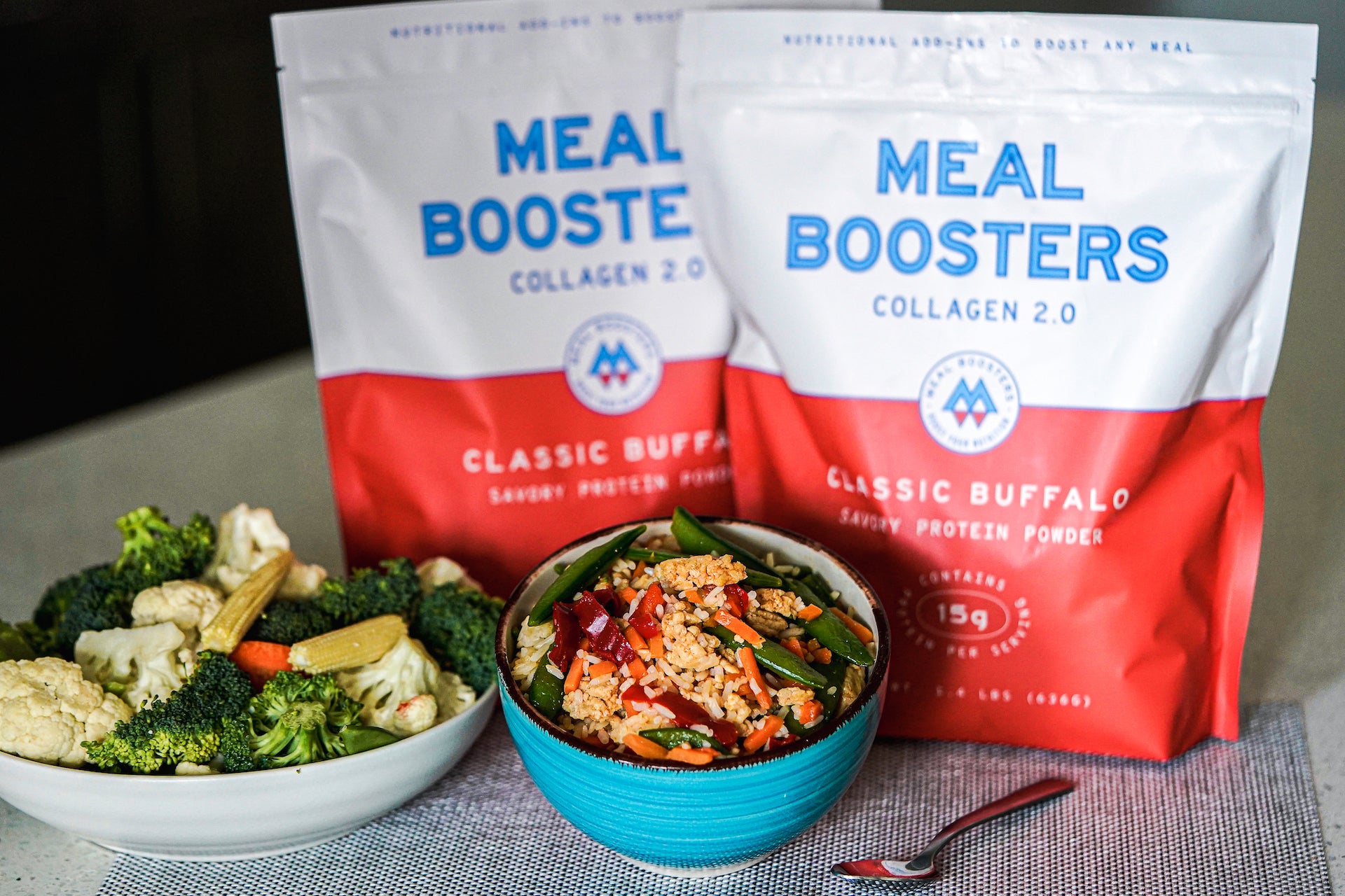 Classic Buffalo Collagen+ Protein Blend powder from Meal Boosters in a container with a scoop of protein powder.