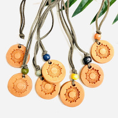 Aromatherapy medallion necklace with a silver chain and decorative pendant, designed for calming essential oils.