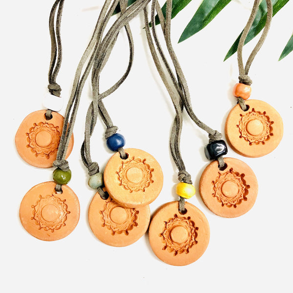 Aromatherapy medallion necklace with a silver chain and decorative pendant, designed for calming essential oils.