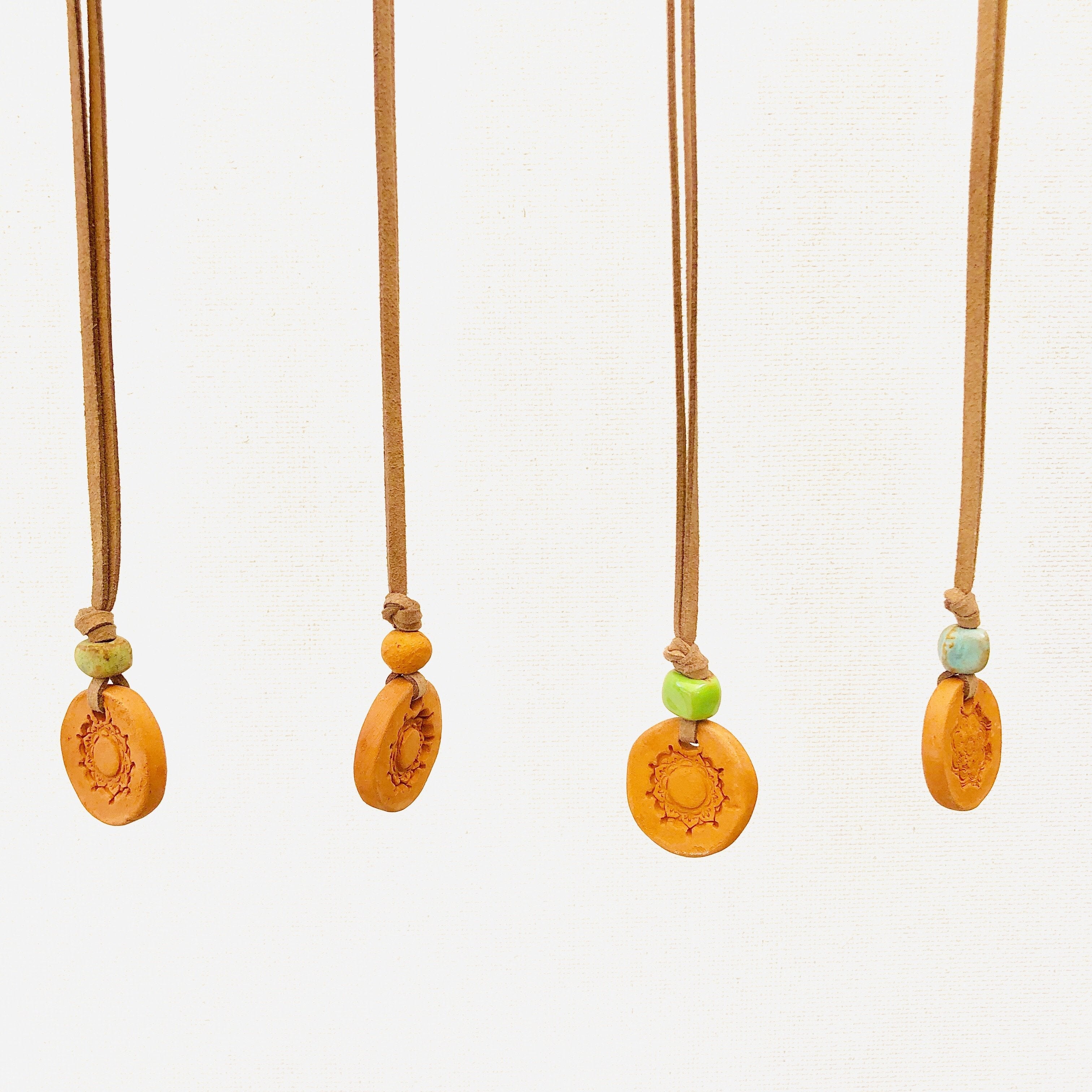 Aromatherapy medallion necklace with a silver pendant and chain, designed for relaxation and stylish wear.