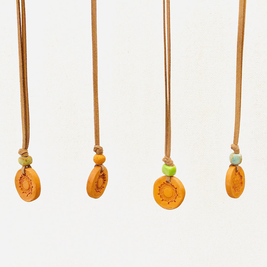 Aromatherapy medallion necklace with a silver pendant and chain, designed for relaxation and stylish wear.