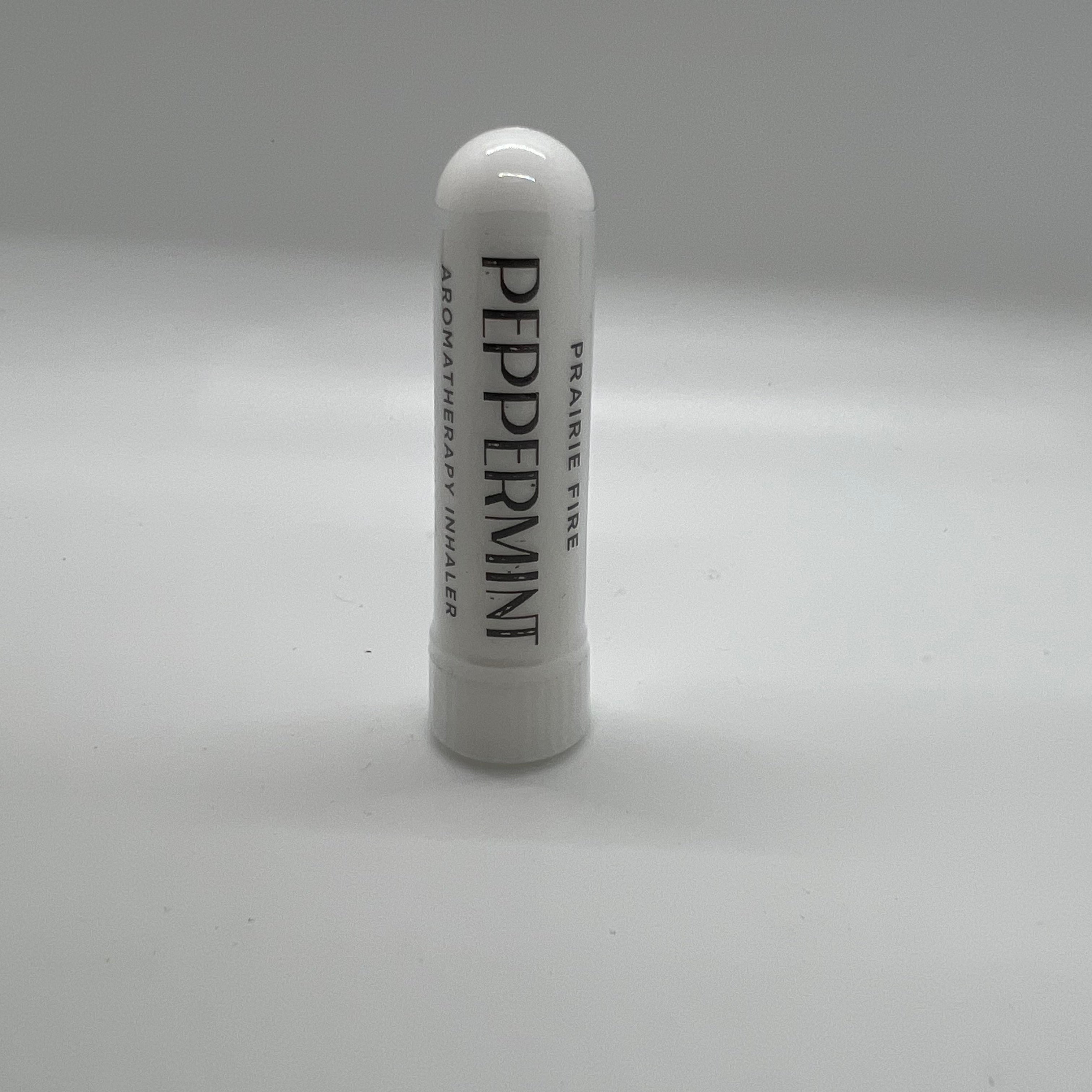 Peppermint aromatherapy inhaler from Prairie Fire Tallow, Candles, and Lavender, featuring a small portable inhaler with peppermint leaves.