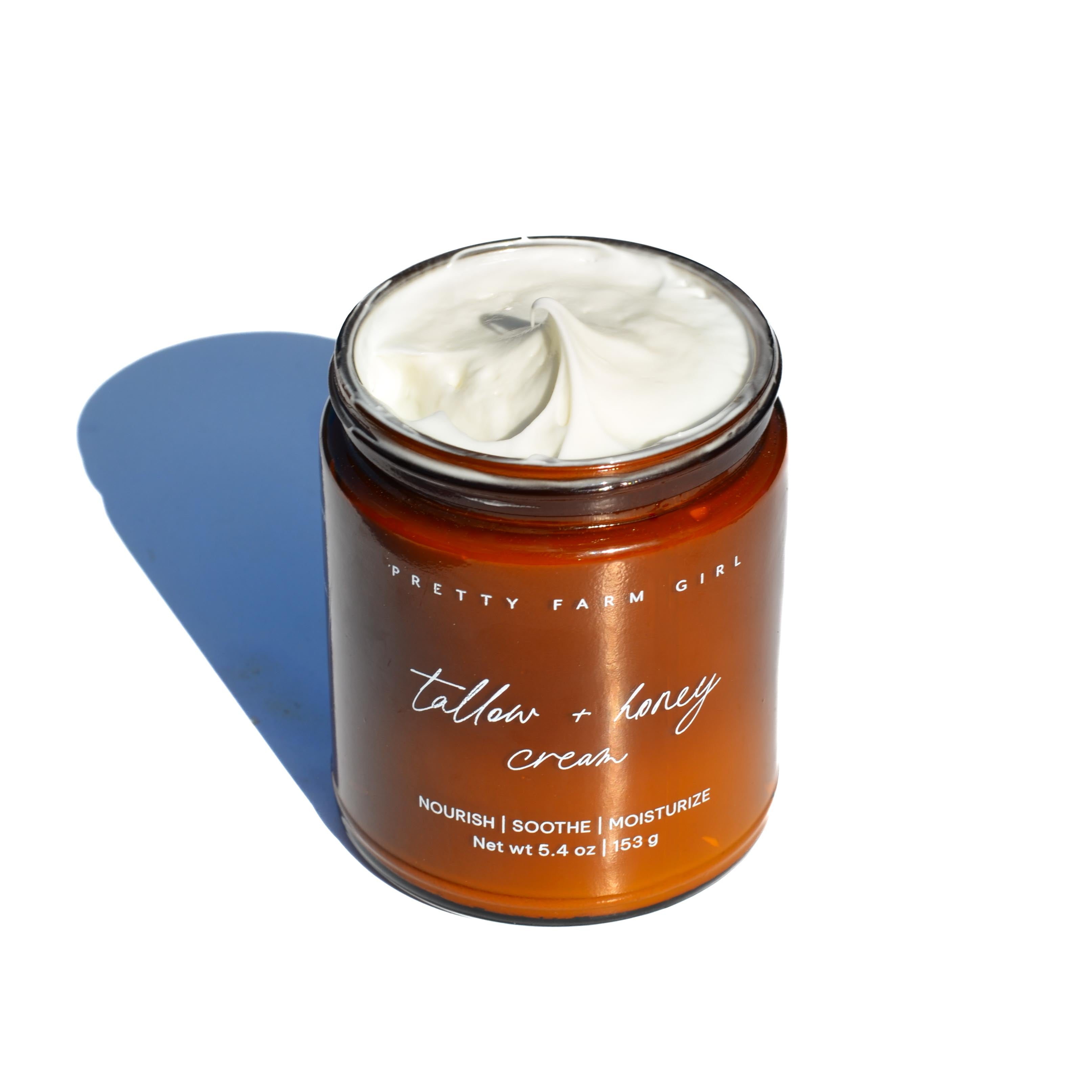 Cream jar of Pretty Farm Girl fragrance-free Tallow and Honey Cream, showing its natural, creamy texture and label.