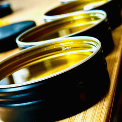 Restalgic Atelier Luxury Beard Balm 2oz jar with a natural wood lid and sleek packaging, designed for grooming and beard care.