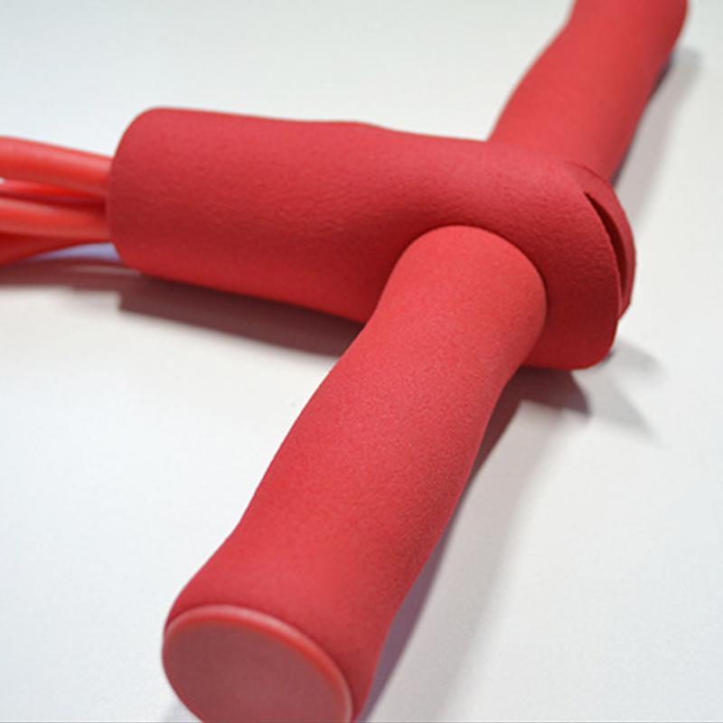 Green natural latex foot pedal elastic pull rope with handles for fitness, bodybuilding, and exercise training.