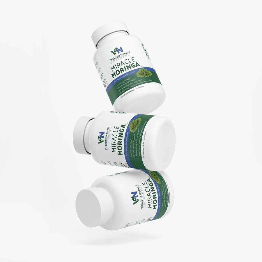 Organic Moringa Pure supplement by Vitalidad Natural in a glass jar with green Moringa leaves and powder inside.
